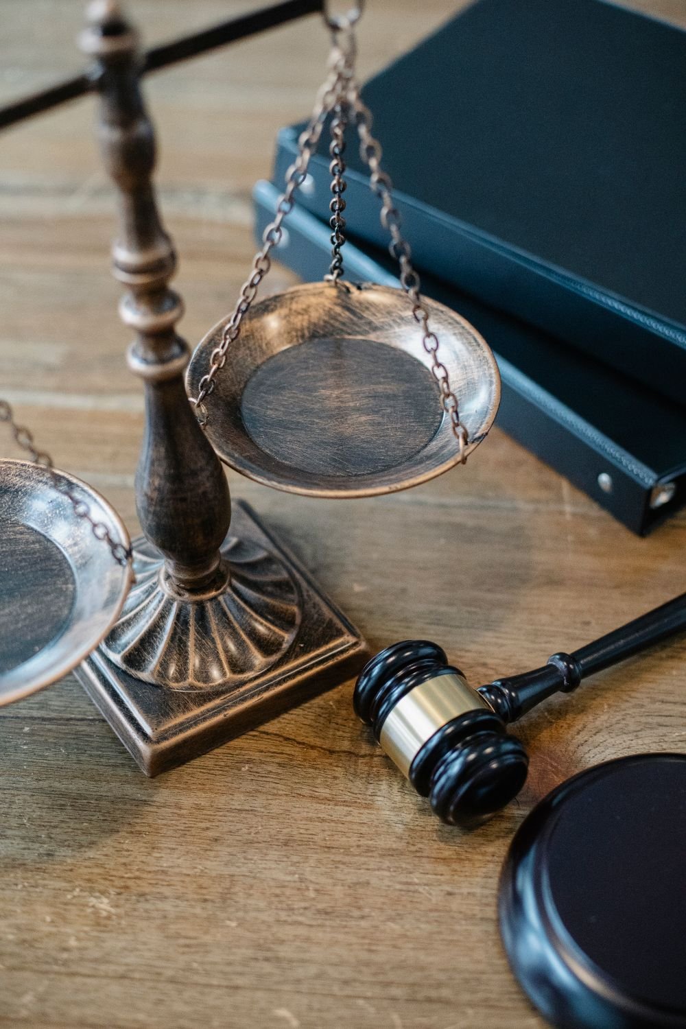 Scales of justice, a gavel, and law books on a wooden desk